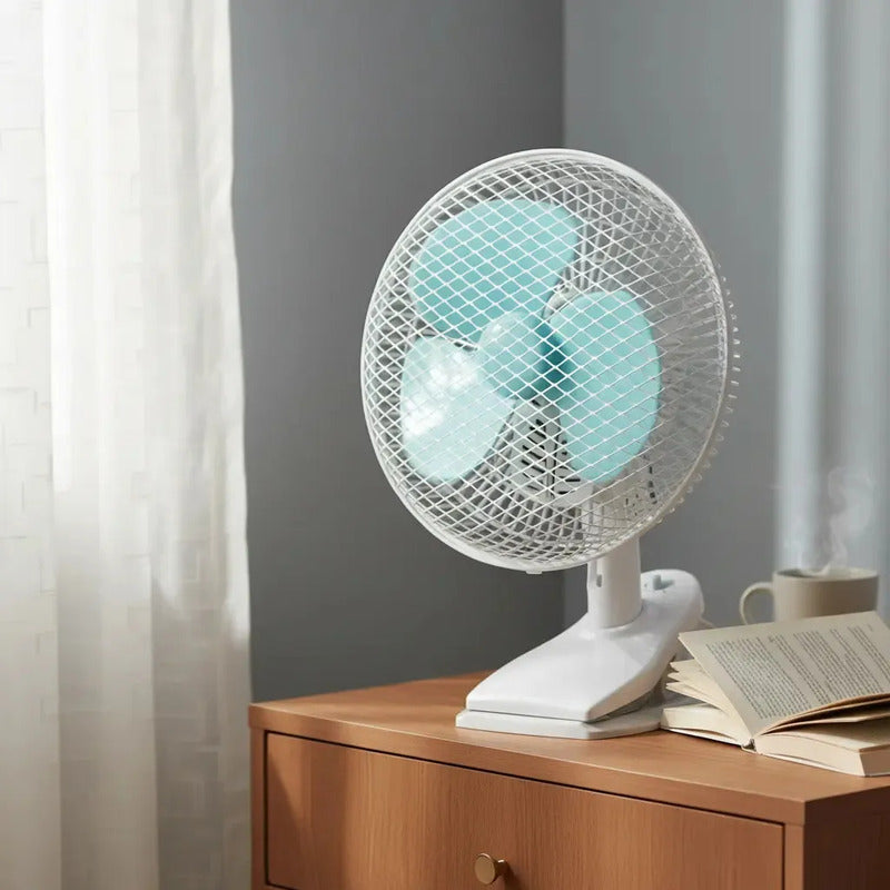 Ventilador compacto sobre escritorio junto a un libro